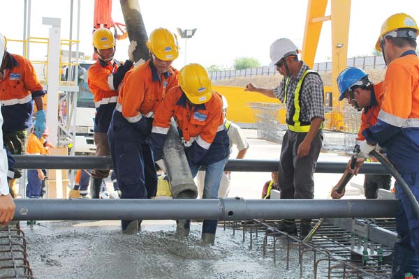 Áo Dạ Quang Bảo Hộ An Toàn Lao Động Tại Bến Tre 3 Công nhân mặc áo phản quang làm việc tại công trường ngoài trời ban ngày