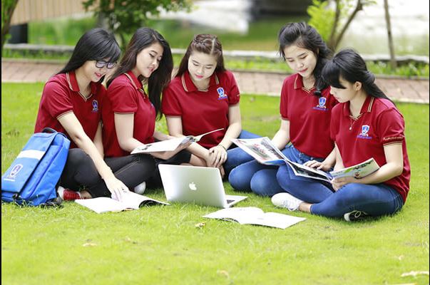 Nhóm học sinh mặc đồng phục ngồi học trong lớp, tay áo gấp gọn