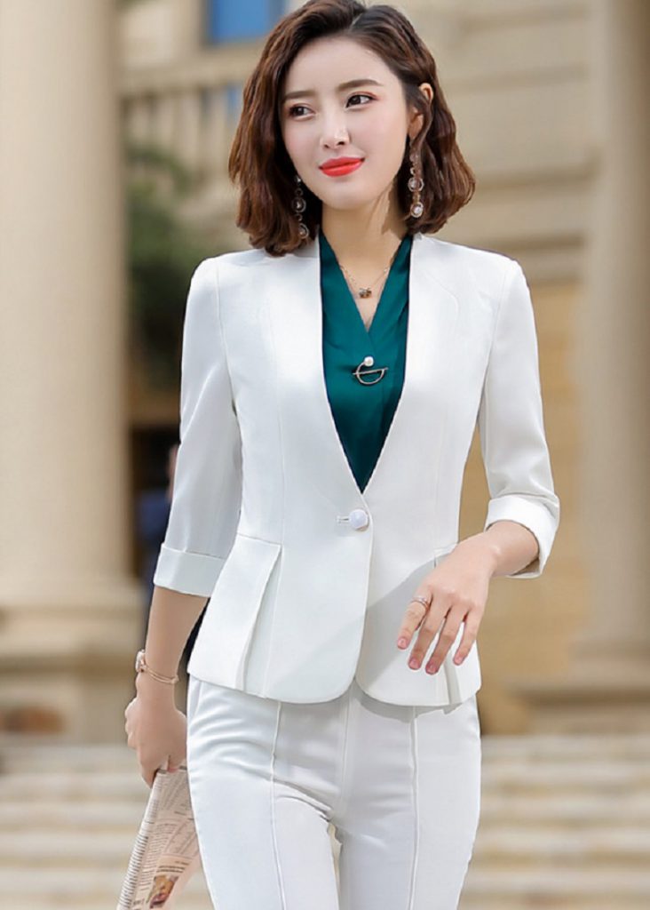 Nhân viên nữ thử bộ vest mẫu để đối chiếu hạ eo sau và vòng bắp tay