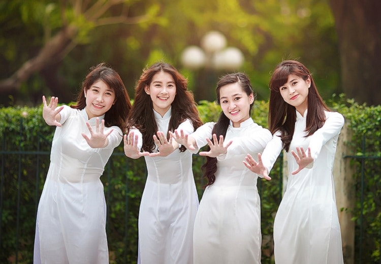 Nữ sinh trung học mặc áo dài trắng trong buổi lễ đầu tuần tại sân trường