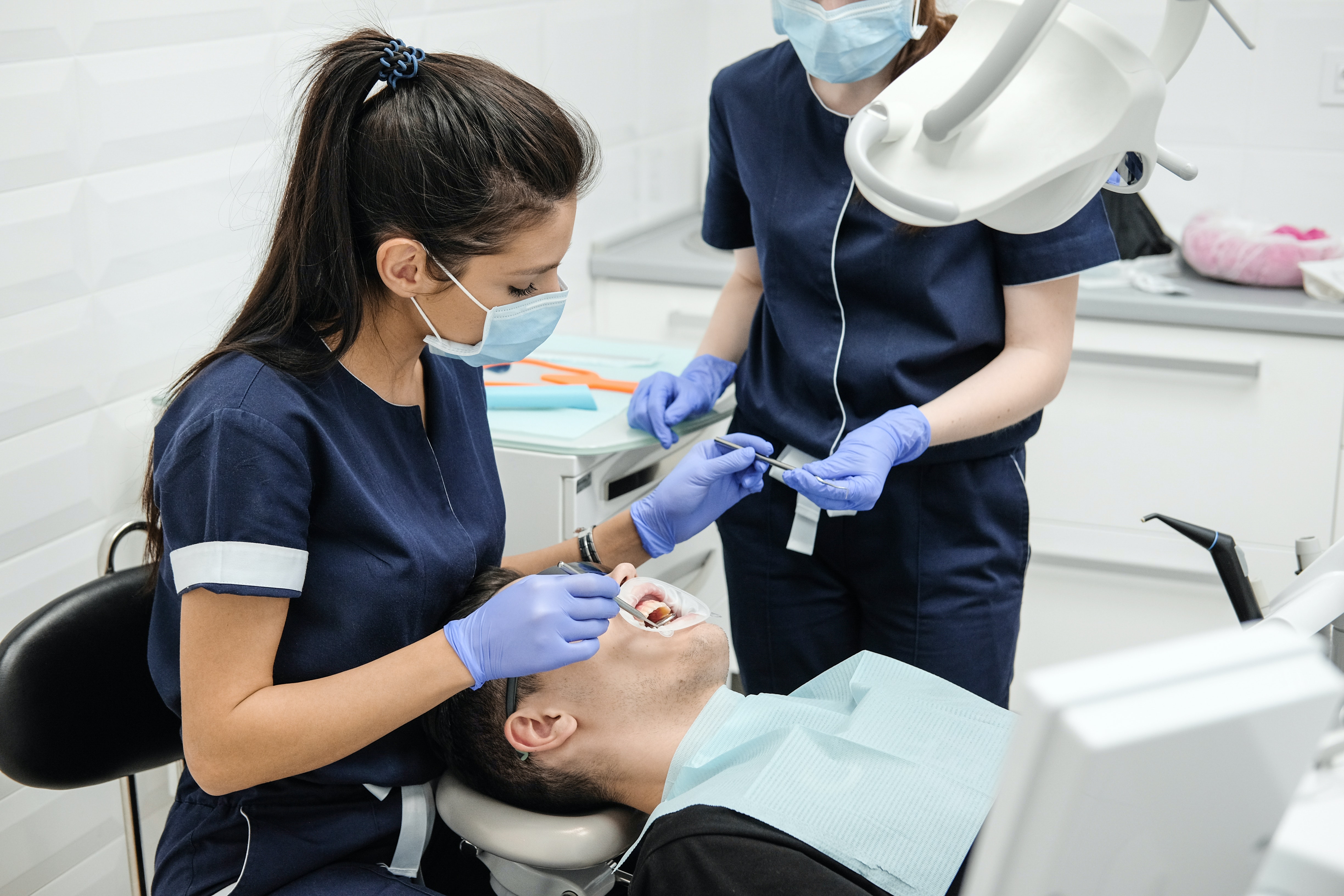 Nhóm nhân viên y tế mặc đồng phục bệnh viện đủ bộ trong hành lang khoa khám